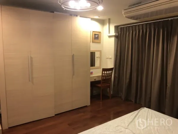 公寓 出租在Bang Rak, Bangkok - 卧室配通顶衣柜、梳妆台、遮光窗帘与壁挂式空调