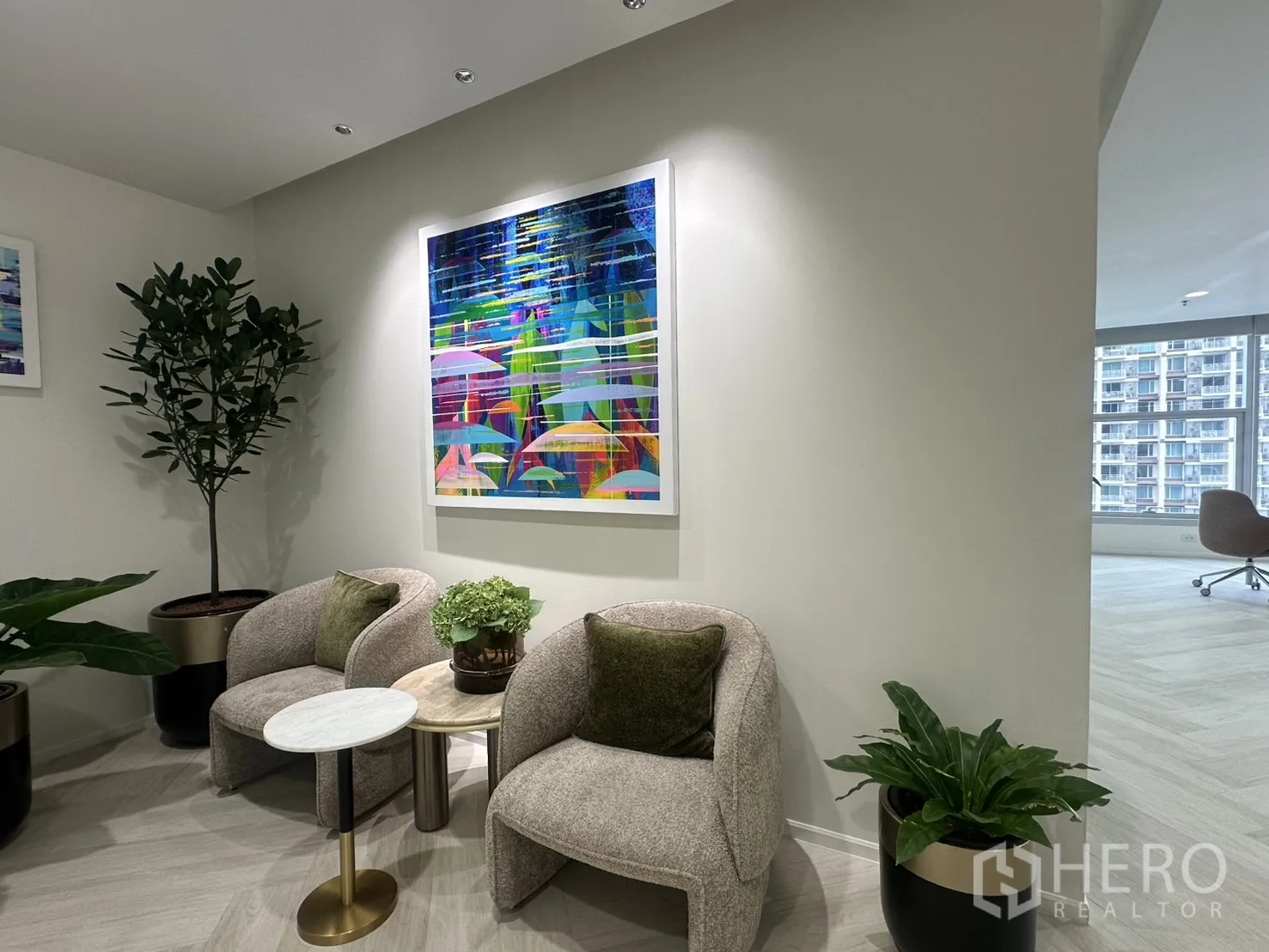 Office Space for rent in Sathon, Bangkok - Cozy waiting nook with two armchairs, side tables, potted plants, and a colorful framed artwork.
