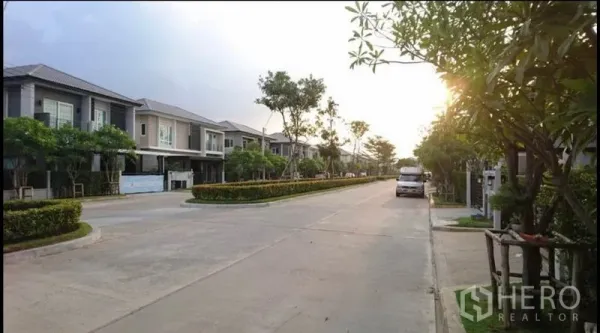 บ้าน ขายในBang Yai, Nonthaburi - ถนนในหมู่บ้านกว้างขวางรายล้อมด้วยต้นไม้และบ้านสองชั้นยามเย็น