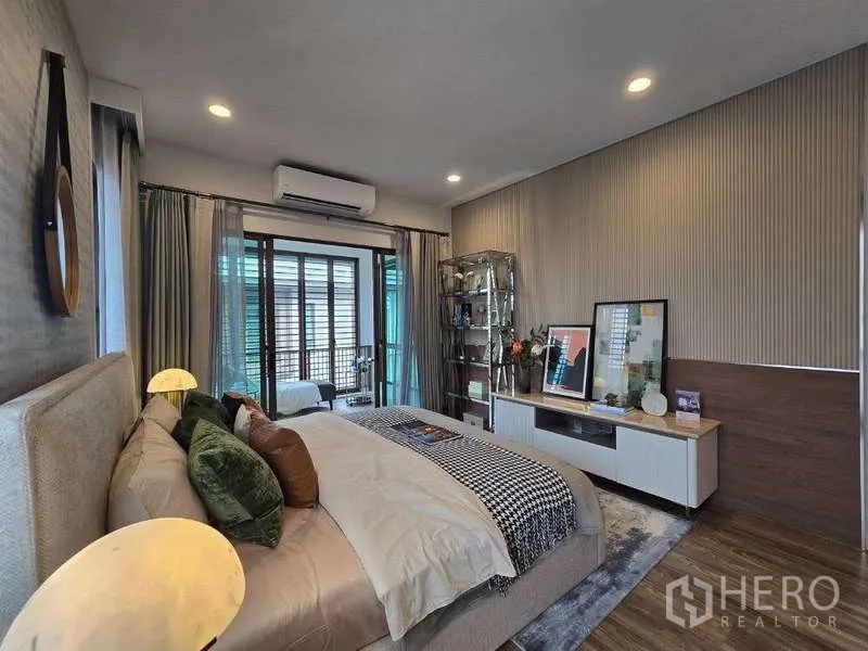 独立式住宅 出租在Bang Kapi, Bangkok - 主卧另一角度，特色墙、电视柜与通往阳台的推拉门。