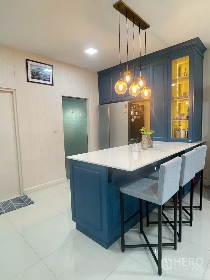Detached House for sale in Bang Phli, Samut Prakan - White-top kitchen island with bar stools and brass pendant lighting.