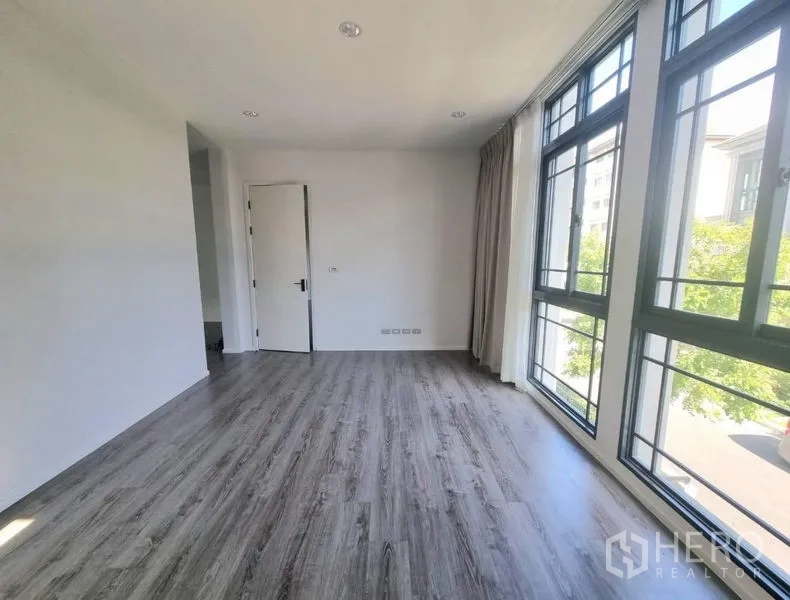 独立式住宅 出租 - 采光充足的卧室，整面黑框窗与灰木地板。