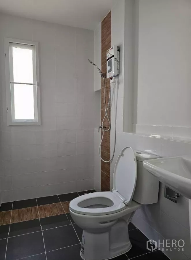 Detached House for rent in Bang Phli, Samut Prakan - Bathroom with shower set, water heater, toilet and window.
