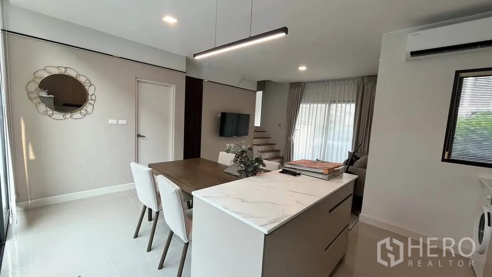 Townhouse for rent or sale in Bang Phli, Samut Prakan - Kitchen counter beside floor‑to‑ceiling sliding glass doors to terrace.