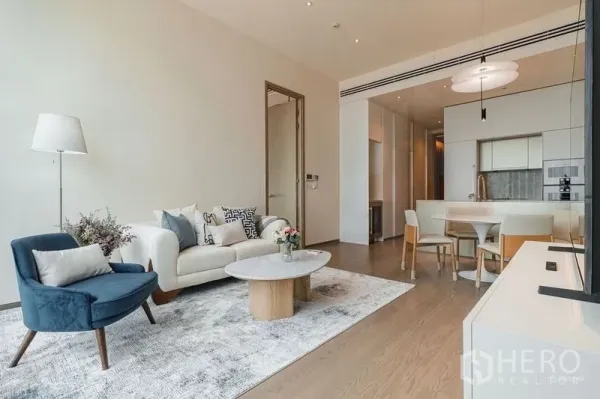 Condominium for rent - Bright open-plan living room with sofa, armchair, rug and kitchen-dining area.