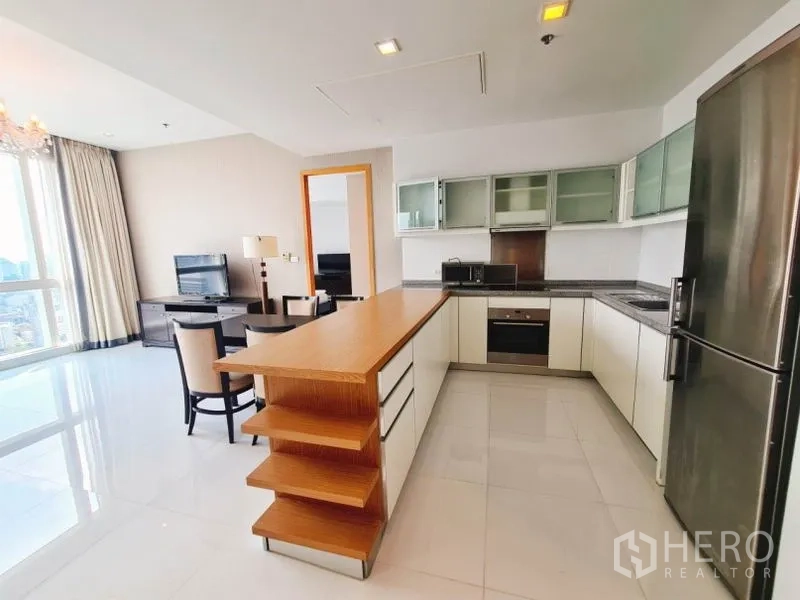 公寓 出租在Khlong Toei, Bangkok - 现代U形厨房，木质岛台台面与不锈钢电器及冰箱。