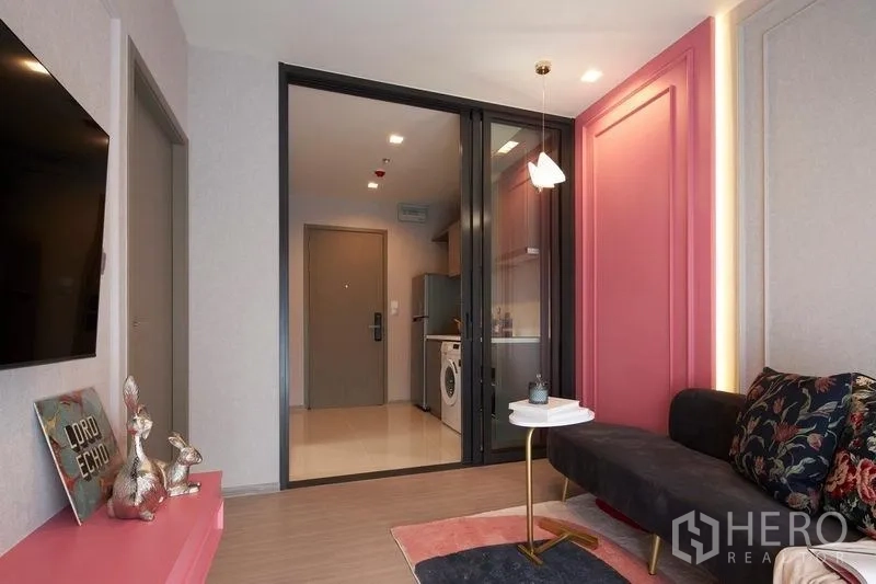 公寓 出售在Ratchathewi, Bangkok - 从客厅望向推拉玻璃后的厨房，配沙发与电视。