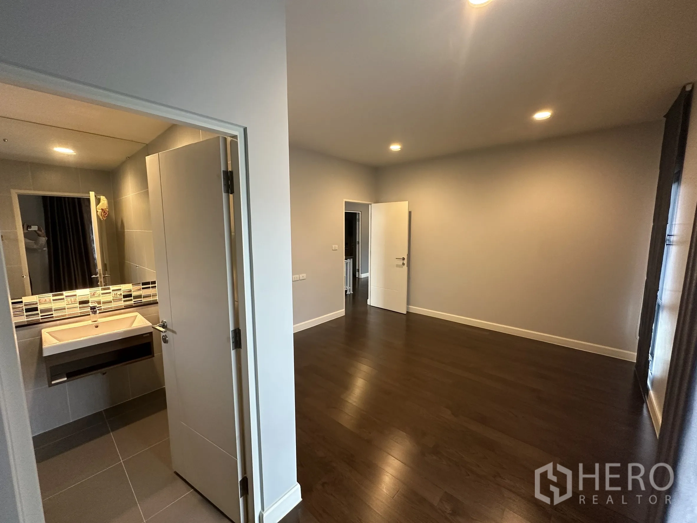 บ้าน ให้เช่าในLam Luk Ka, Pathum Thani - ห้องนอนมีห้องน้ำในตัว พื้นไม้ และมุมอ่างล้างหน้า