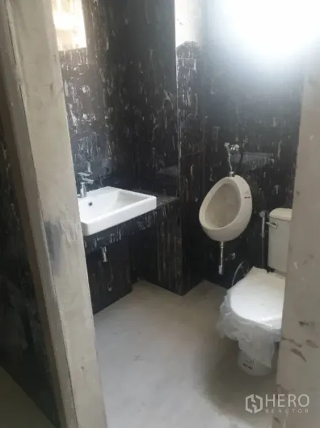 Office Space for rent in Khlong Toei, Bangkok - Men’s restroom with urinal, toilet, and white sink against dark tiled walls.