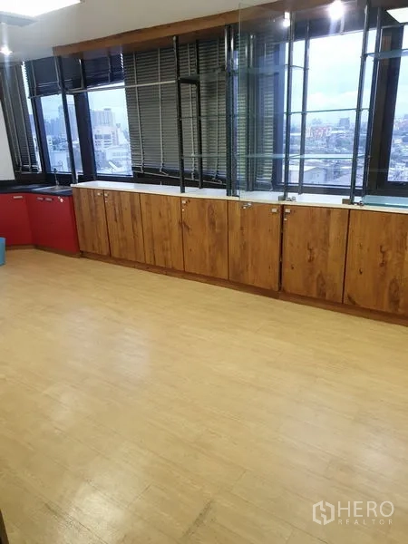 Office Space for rent - Corner office with wide windows, city views and built-in wooden cabinets.