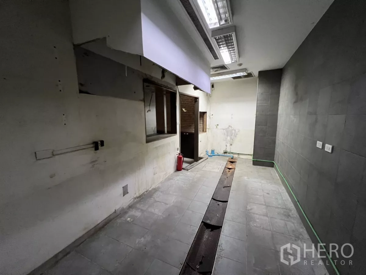 พื้นที่ขายปลีก ให้เช่า - พื้นที่เตรียมครัวหลังร้าน พื้นกระเบื้อง ไฟฟลูออเรสเซนต์ และช่องเสิร์ฟ