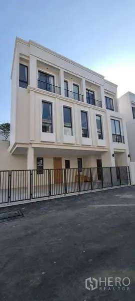 บ้าน ให้เช่าในLat Krabang, Bangkok - ด้านหน้าบ้านสไตล์โมเดิร์นสามชั้น พร้อมรั้วโลหะและที่จอดรถ ใน AERIE ลาดกระบัง