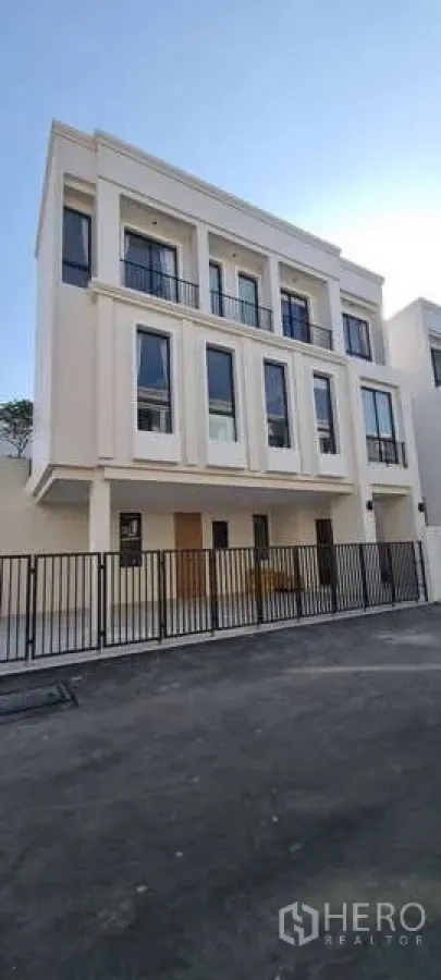 บ้าน ให้เช่าในLat Krabang, Bangkok - ด้านหน้าบ้านสไตล์โมเดิร์นสามชั้น พร้อมรั้วโลหะและที่จอดรถ ใน AERIE ลาดกระบัง