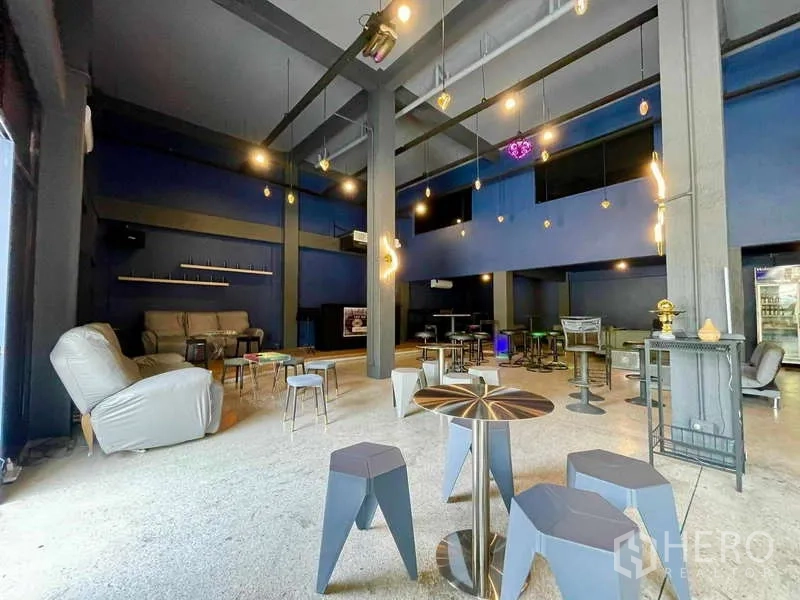 店屋 出租在Lat Phrao, Bangkok - 开放式咖啡厅风格区域，挑高天花与现代吊灯、吧椅。