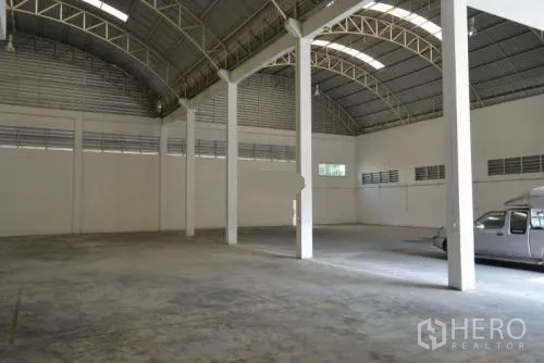 货栈 出租在Samut Sakhon - 空旷的仓库大厅，带采光窗、通风窗和白色支柱。