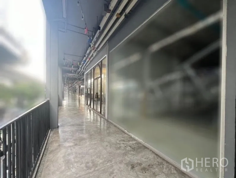 零售空间 出租在Khlong Toei, Bangkok - 铺位外的露天连廊，店面与护栏一字排开。