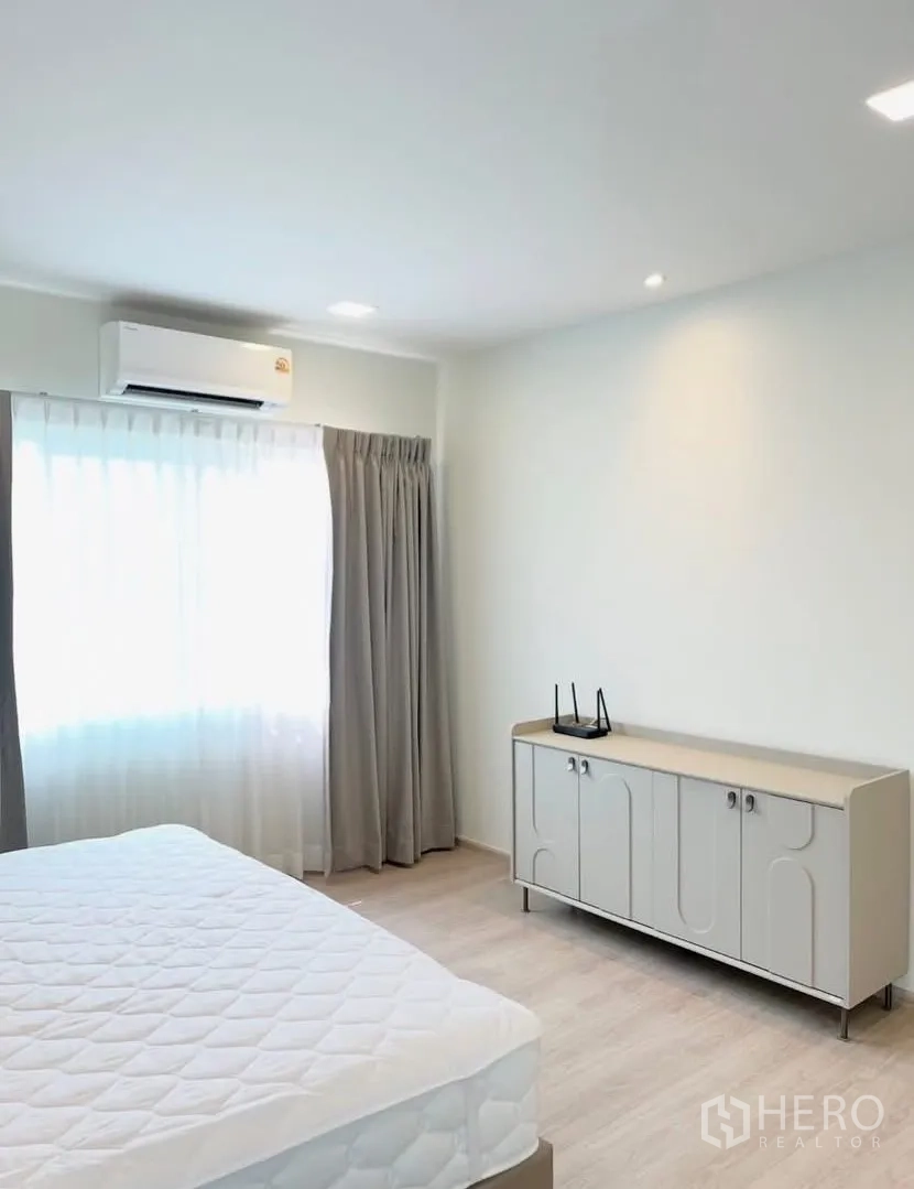 Detached House for rent in Bang Phli, Samut Prakan - Bright bedroom with double bed, air conditioner, sideboard, and curtained window.