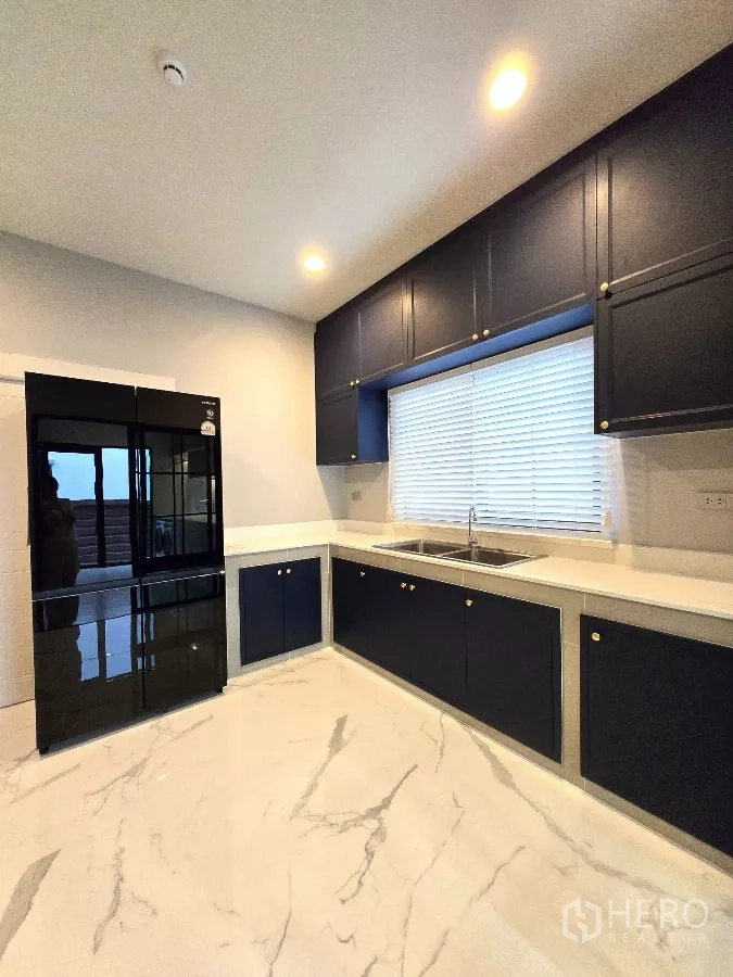 Detached House for rent in Bang Phli, Samut Prakan - Enclosed Thai kitchen with black double-door fridge and dark cabinetry.