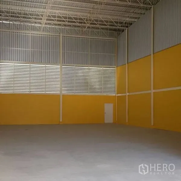 คลังสินค้า ให้เช่าในMueang Samut Prakan, Samut Prakan - ภายในโกดังเพดานสูง โครงเหล็ก ช่องลมระบายอากาศ ผนังสีเหลือง และพื้นคอนกรีตเรียบ