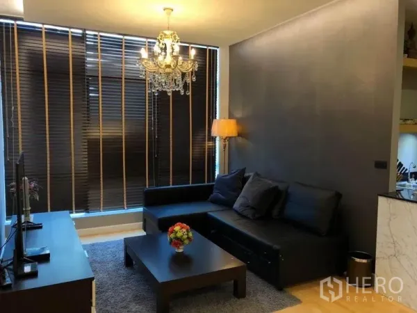 คอนโด ให้เช่าในKhlong San, Bangkok - มุมนั่งเล่นโซฟาเข้ามุม โคมระย้า และม่านปรับแสงเต็มผนัง