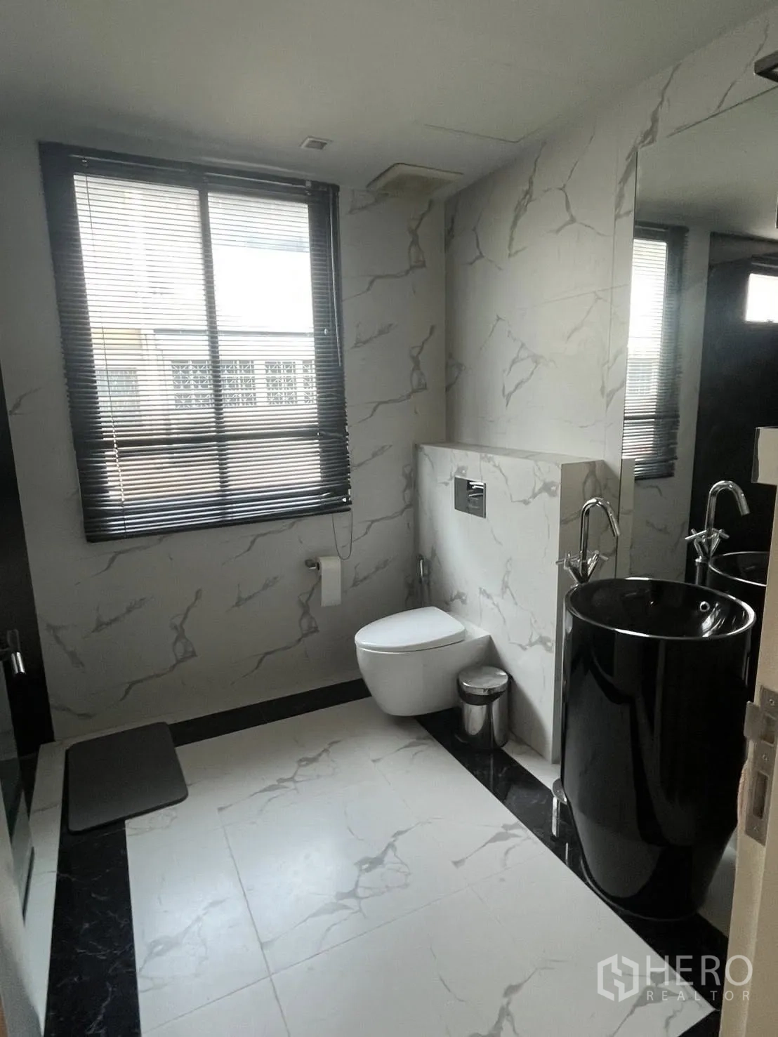 Home Office for rent in Watthana, Bangkok - Contemporary bathroom with marble-effect tiles and a black pedestal sink.