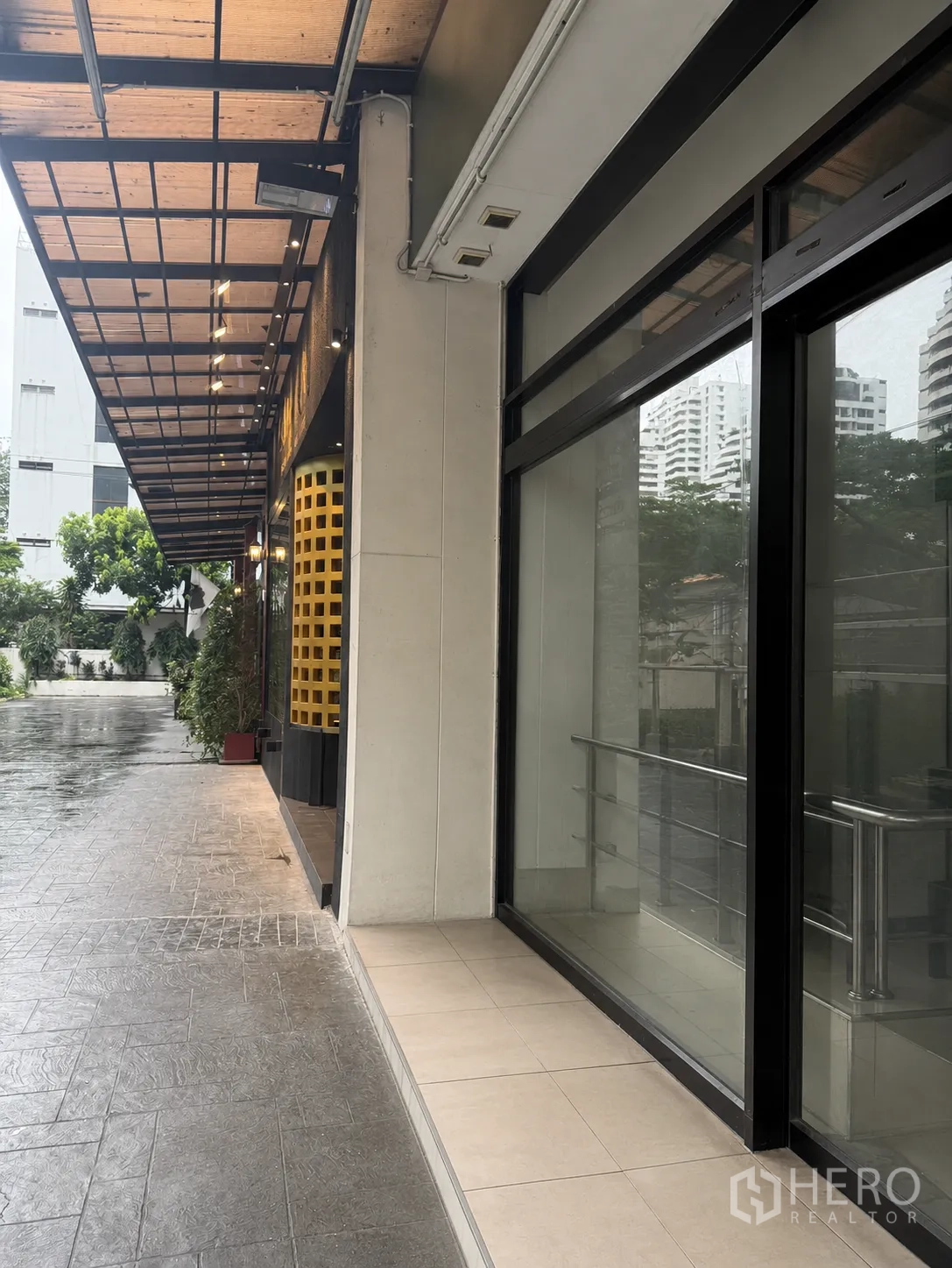 Retail Space for rent in Watthana, Bangkok - Covered sidewalk beside a retail unit with large glass windows and metal canopy.