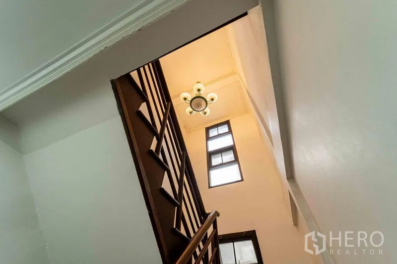 สำนักงานที่บ้าน ให้เช่าในBang Rak, Bangkok - โถงบันไดราวไม้ เพดานสูงมีโคมไฟและหน้าต่างรับแสงธรรมชาติ