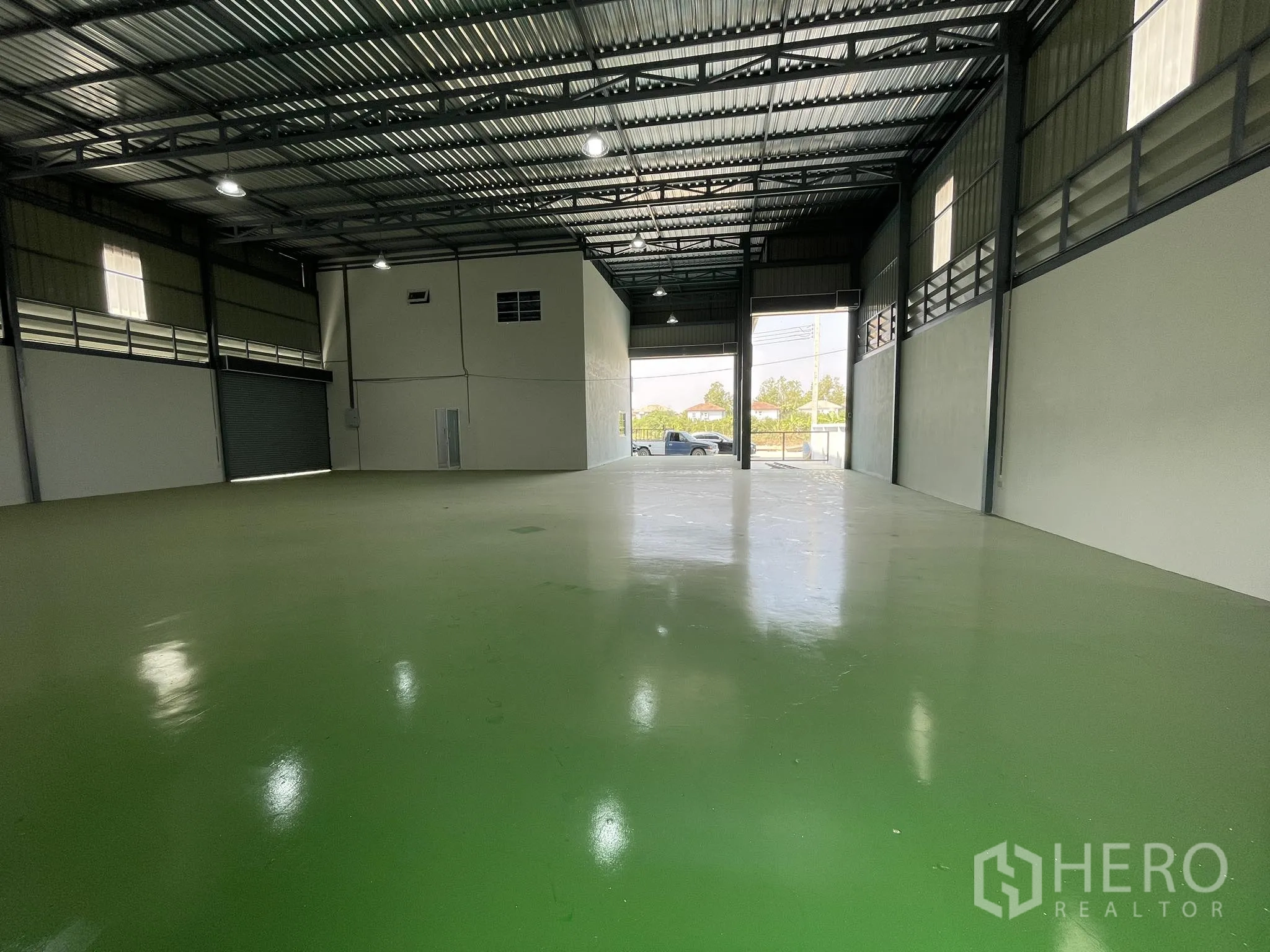 Factory for rent or sale in Bang Phli, Samut Prakan - Warehouse interior facing wide roller doors and open front yard access.