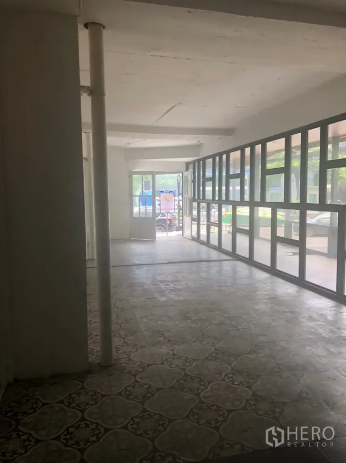 零售空间 出租在Khlong Toei, Bangkok - 一层空置商铺内景，花纹地砖与整面玻璃门面，临近BTS通罗站。