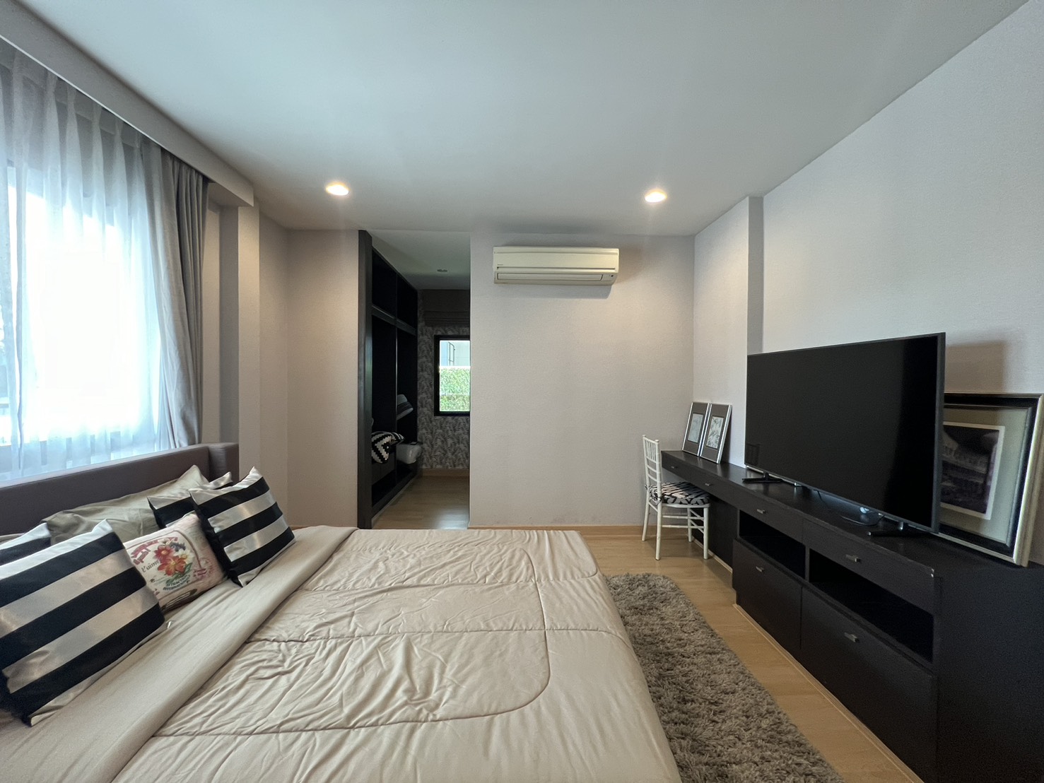 Detached House for rent in Bang Kapi, Bangkok - Cozy bedroom with TV cabinet, work desk and soft lighting.