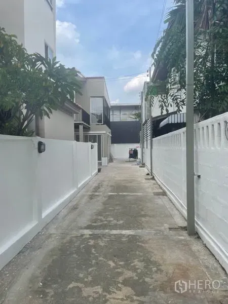 บ้าน ให้เช่าในHuai Khwang, Bangkok - ซอยส่วนตัวกำแพงสีขาว นำไปสู่ตัวบ้านเดี่ยว พร้อมพื้นที่จอดรถริมทาง.