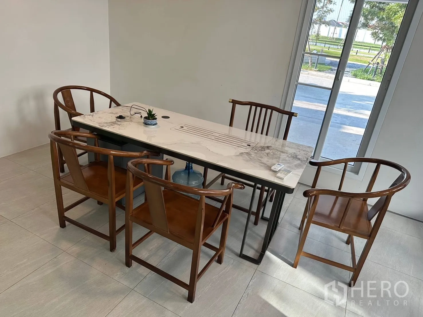 Detached House for rent in Bang Phli, Samut Prakan - Dining area with marble-top table and wooden chairs beside sliding doors.
