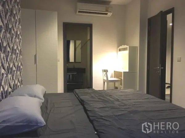 คอนโด ให้เช่าในWatthana, Bangkok - ห้องนอนมีตู้เสื้อผ้า โต๊ะเครื่องแป้ง และทางเชื่อมเข้าห้องน้ำ แสงไฟอบอุ่น