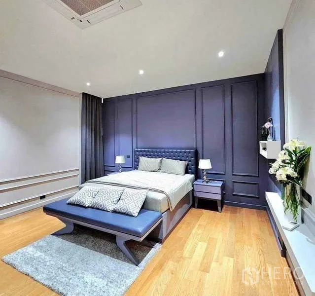 บ้าน ขายในKhlong Sam Wa, Bangkok - ห้องนอนสไตล์ร่วมสมัย ผนังกรุสีกรมท่า มีม้านั่งปลายเตียง โต๊ะข้าง และพื้นไม้โทนอุ่น