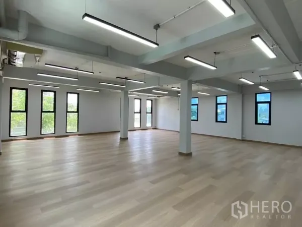 สำนักงานที่บ้าน ให้เช่าในPhra Khanong, Bangkok - ชั้นสำนักงานโอเพ่นสเปซ พื้นไม้สีอ่อน ไฟ LED เรียงเป็นแนว หน้าต่างสูงรับแสงธรรมชาติ