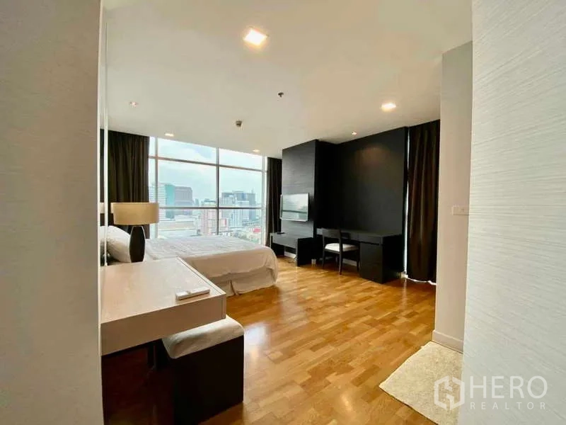 公寓 出租或出售在Sathon, Bangkok - 主卧带书桌，整面落地窗观赏曼谷天际线。