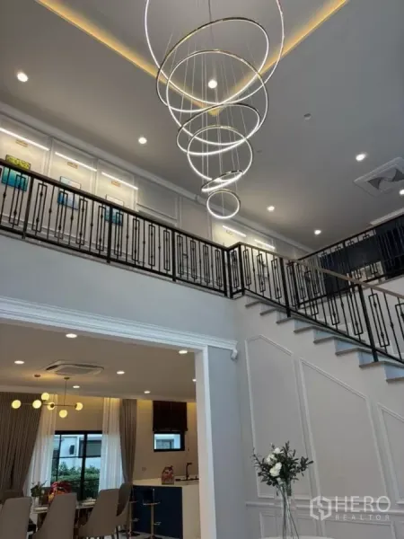 独立式住宅 出租在Bang Phli, Samut Prakan - 圆环吊灯特写与客厅上方的夹层走廊。