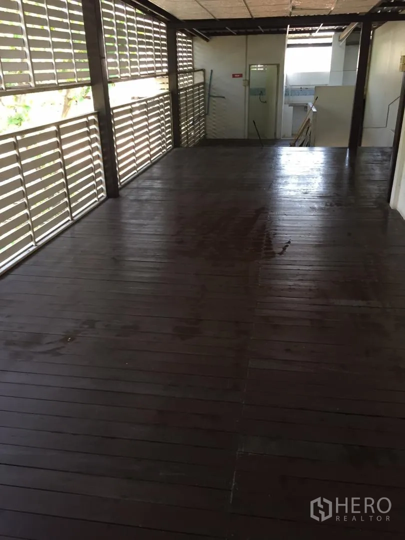 Home Office for rent or sale in Bang Khun Thian, Bangkok - Covered wooden deck corridor with slatted screens providing shade and ventilation.