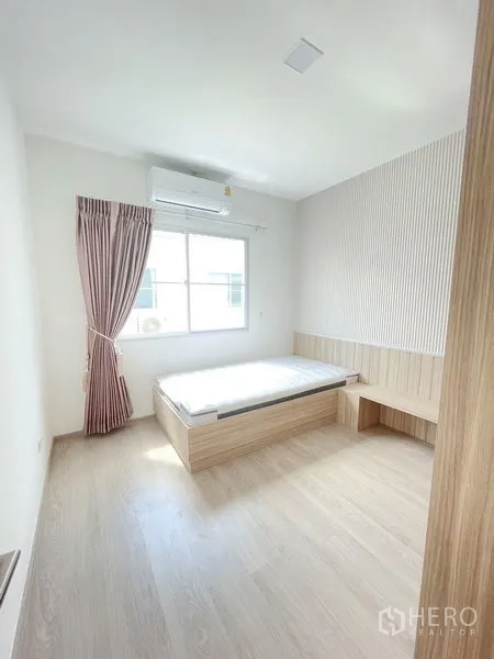 联排别墅 出租在Prawet, Bangkok - 采光充足的卧室，平台床、空调与纹理背景墙。