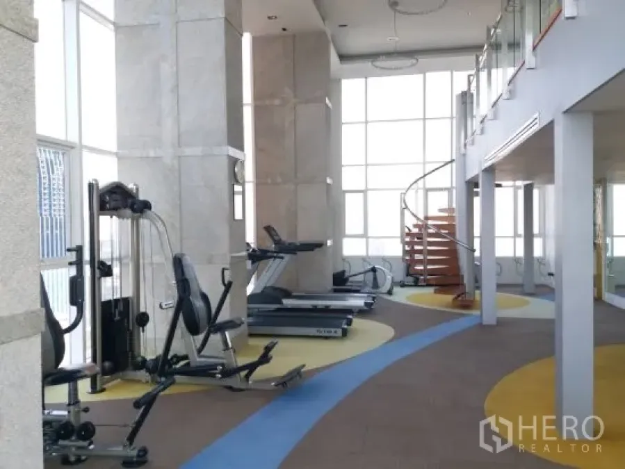 公寓 出租在Pathum Wan, Bangkok - 采光充足的健身房，配跑步机、力量器械和旋转楼梯的公寓设施