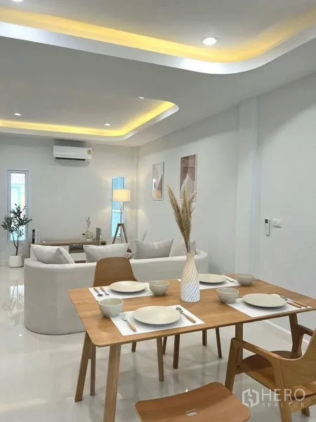 联排别墅 出售在Khlong Toei, Bangkok - 餐区朝向明亮客厅，跌级吊顶灯光与光亮地面。