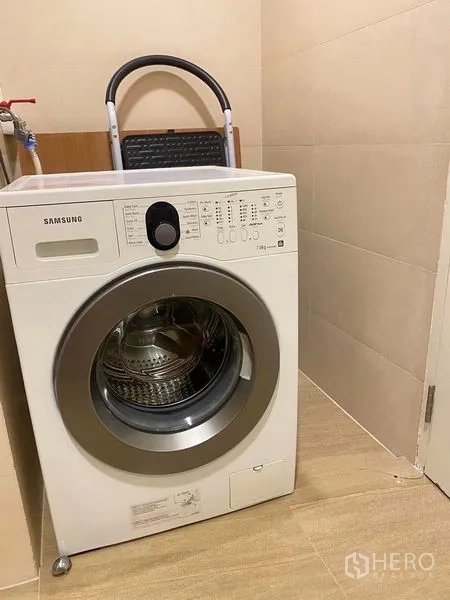 คอนโด ให้เช่าหรือขายในBang Kapi, Bangkok - มุมซักผ้าพร้อมเครื่องซักผ้าแบบฝาหน้า บนพื้นกระเบื้องสีเบจ