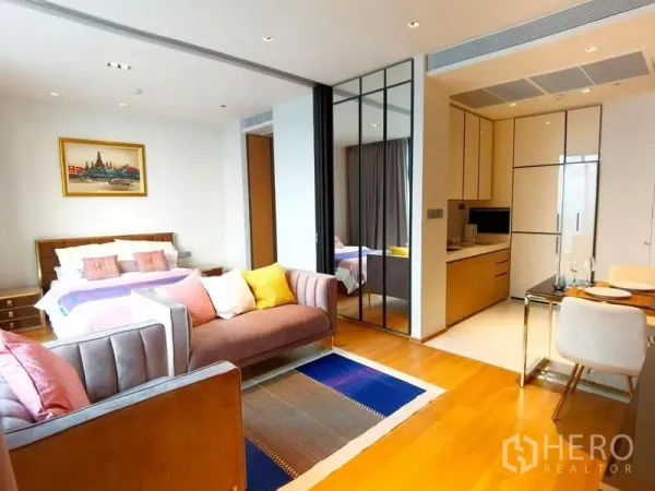 คอนโด ให้เช่าในKhlong Toei, Bangkok - คอนโดแผนผังเปิดโล่งสว่าง พร้อมเตียง โซฟา ครัวขนาดกะทัดรัด และผนังกระจกเงาบนพื้นไม้