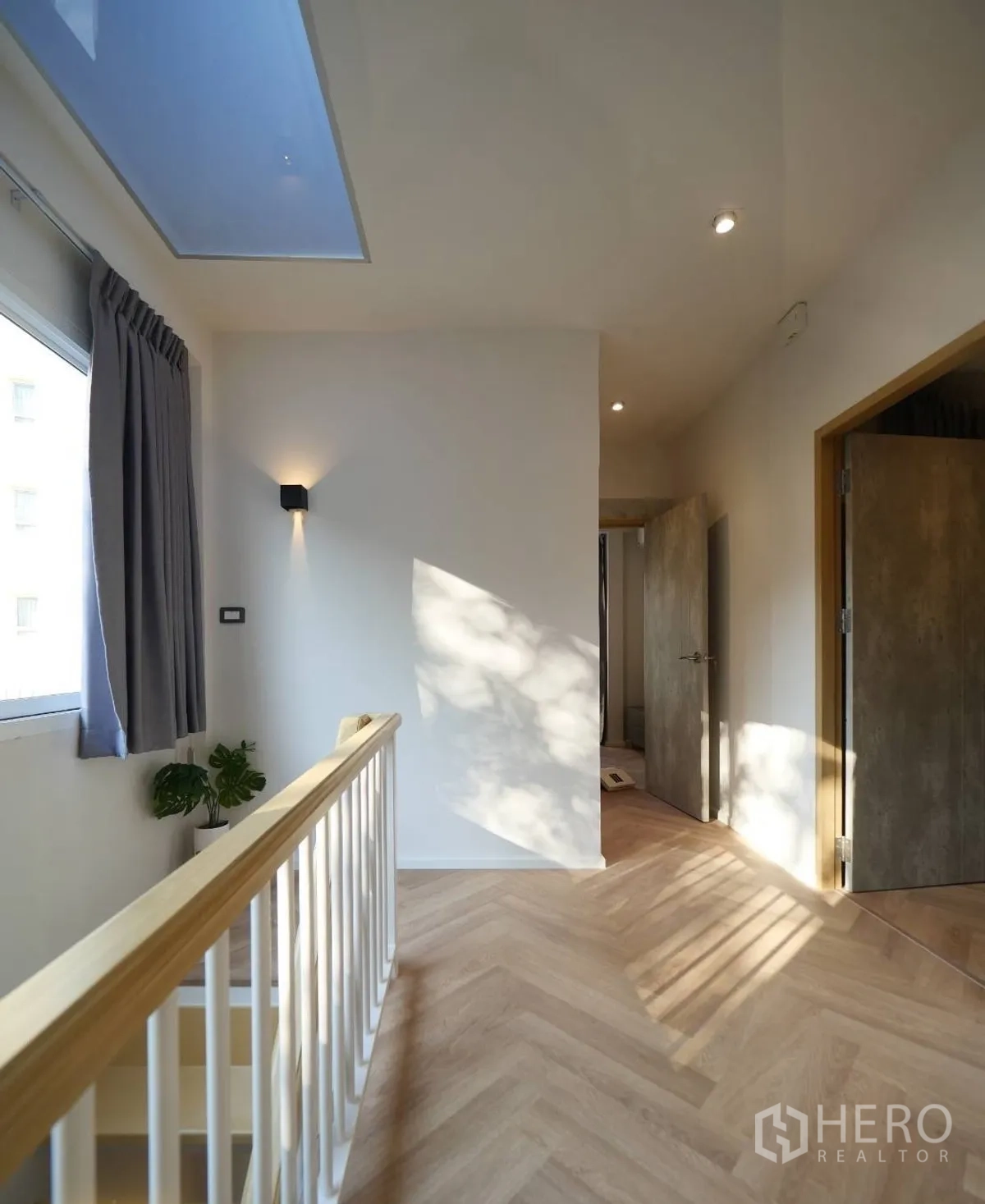 联排别墅 出租或出售在Watthana, Bangkok - 明亮的二楼走廊，天窗、木扶手与人字拼地面。