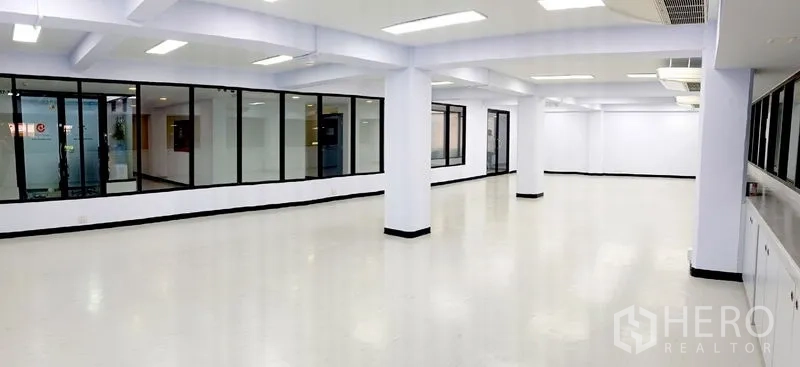 办公空间 出租在Watthana, Bangkok - 明亮的开放式办公室，白色地面与立柱，玻璃隔断会议室。