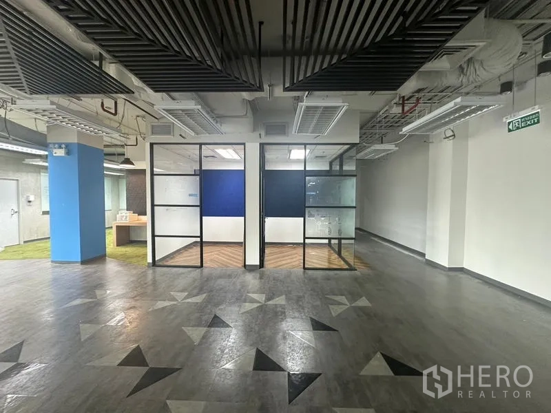 Office Space for rent in Bang Rak, Bangkok - Corridor facing two glass-partitioned rooms with a geometric-pattern vinyl floor.