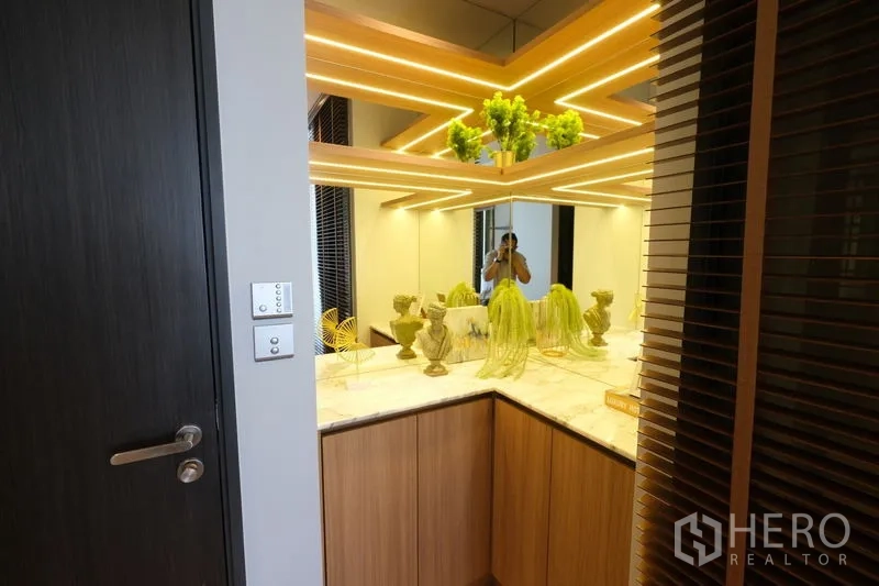 公寓 出租 - 装饰角落，镜面墙与线性LED灯，石材台面摆放绿植。