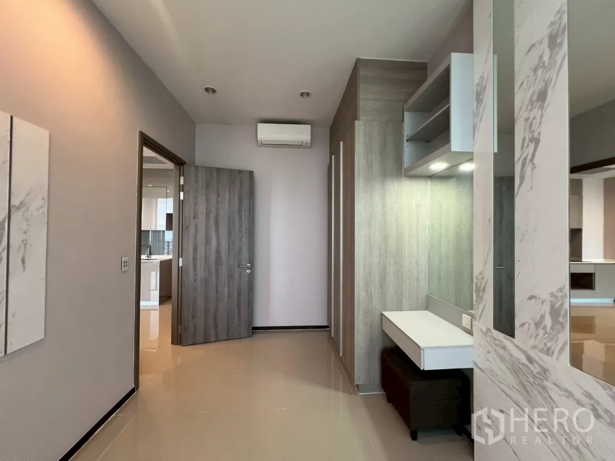 Condominium for rent in Phra Khanong, Bangkok - Bedroom or study with vanity nook, wood-tone doors, and view to bathroom.