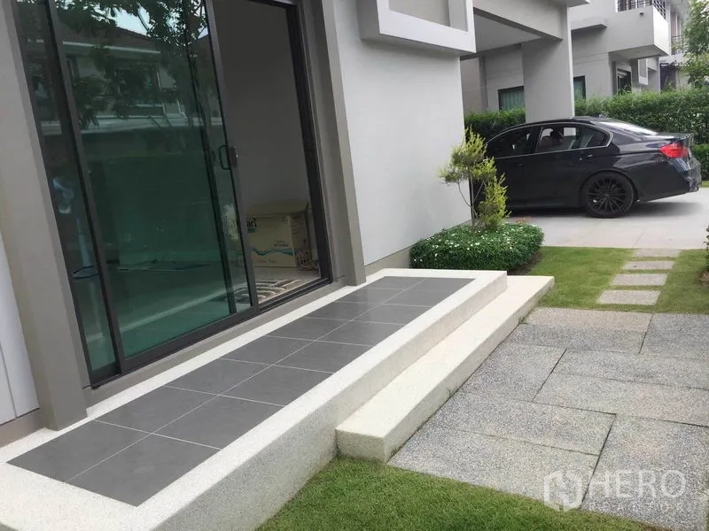 Detached House for sale in Pak Kret, Nonthaburi - Front patio with sliding glass doors next to driveway and shrubs