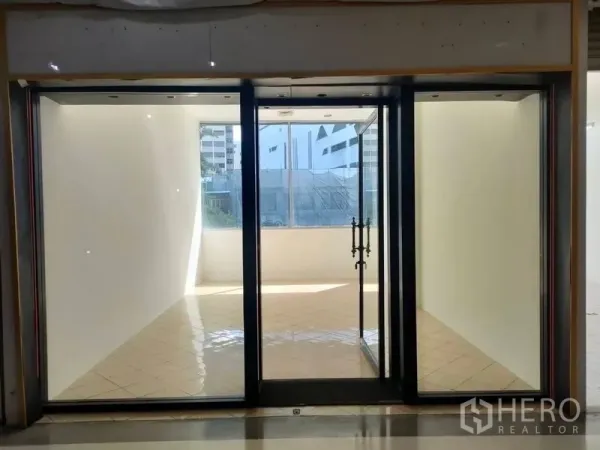 พื้นที่ขายปลีก ให้เช่า - พื้นที่ค้าปลีกขนาด 25 ตร.ม. ว่าง หน้าร้านกระจกเต็มบาน ประตูกระจกคู่ ผนังสีขาว พื้นกระเบื้อง